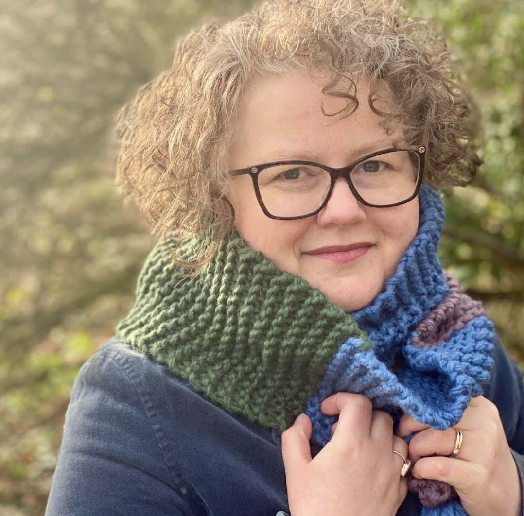 Hannah wearing a thick wintery green blue and purplescarf close up